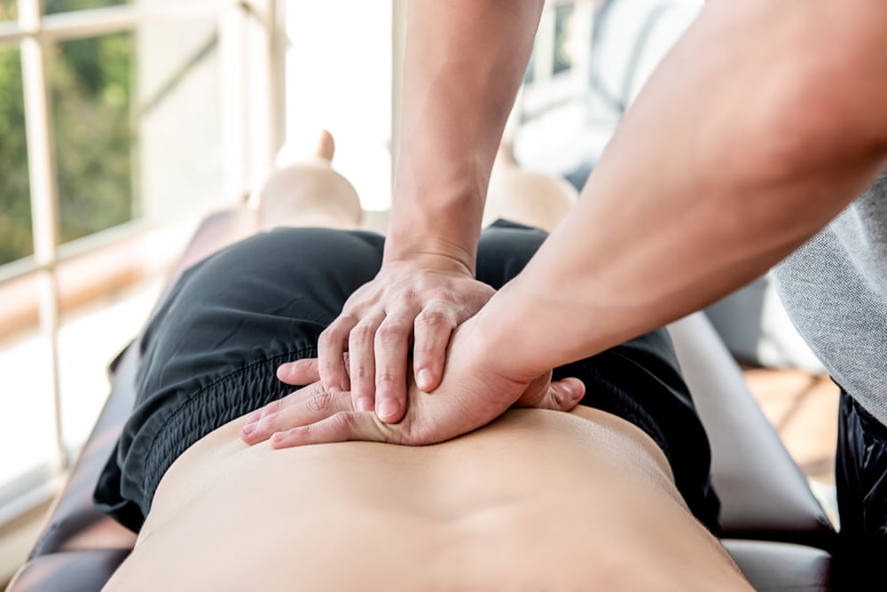 Physical therapist treating man at back pain clinic