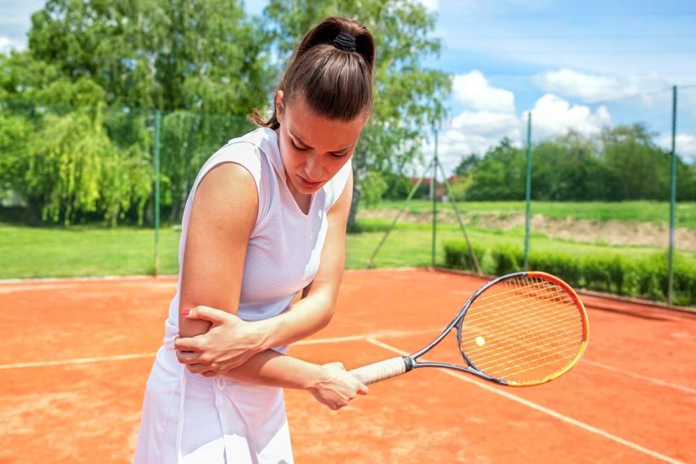 Female tennis player with sports injury to elbow